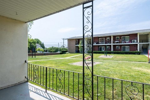 the view of a yard from the balcony of an apartment building