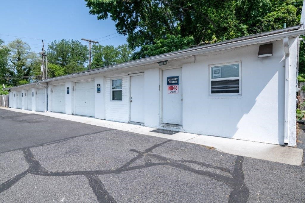 a white building with white doors and a sign on the side of it