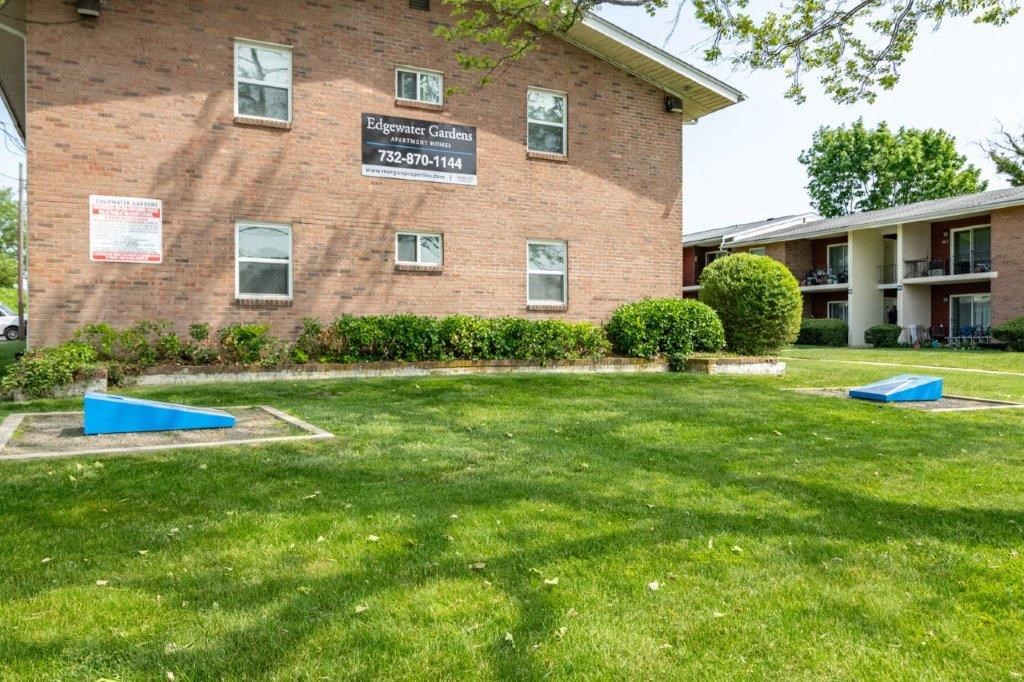 a brick building with two blue benches in the grass