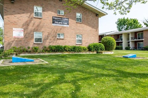 a brick building with two blue benches in the grass