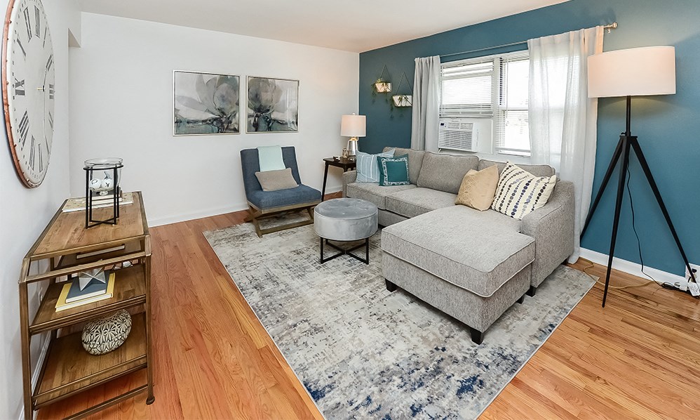 a living room with blue walls and a gray couch