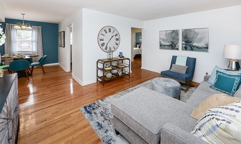 a living room with a couch and a large clock on the wall