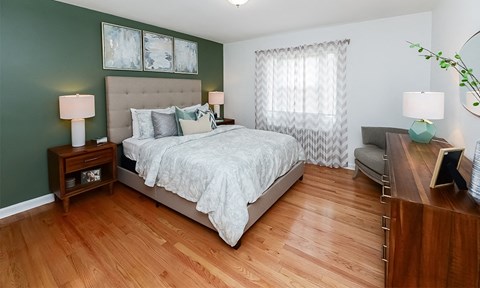 a bedroom with green walls and wood floors and a bed