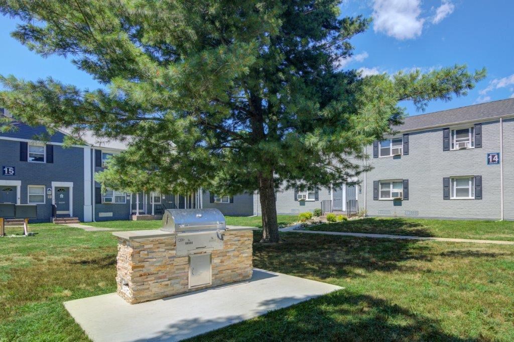 an outdoor grill in front of an apartment building