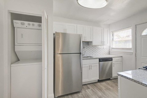 a kitchen with white cabinets and a stainless steel refrigerator