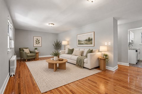 A living room with a white couch, a coffee table, and a painting on the wall.