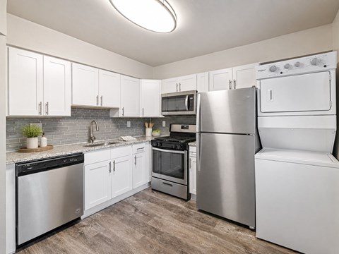 A kitchen with white appliances and cabinets.