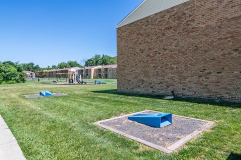 a picnic area in the grass near a brick building