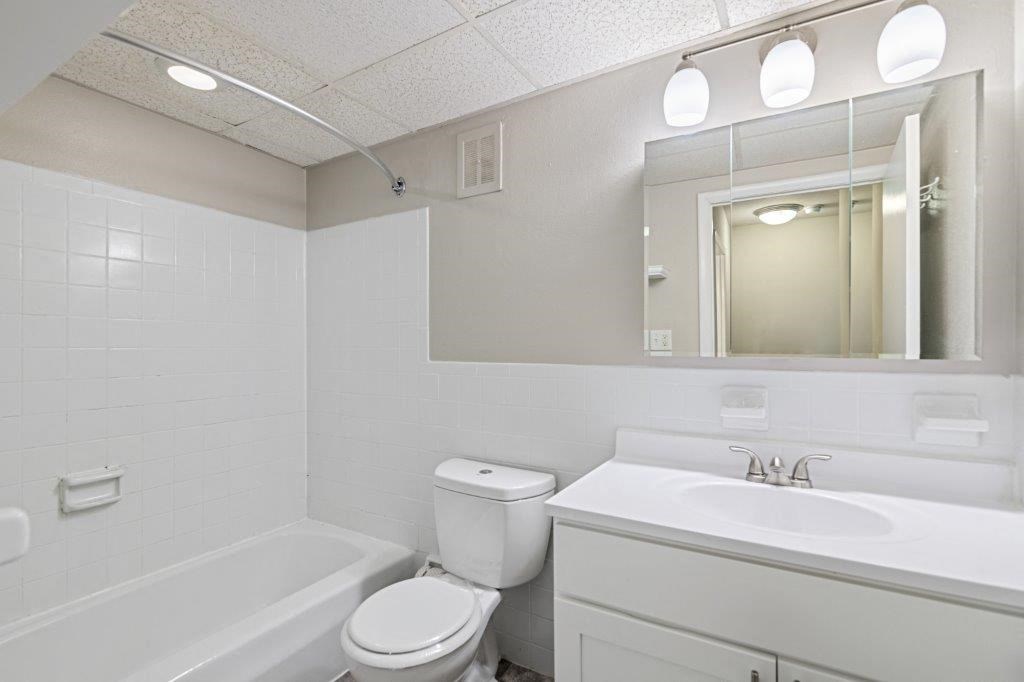 a bathroom with a sink toilet and a mirror