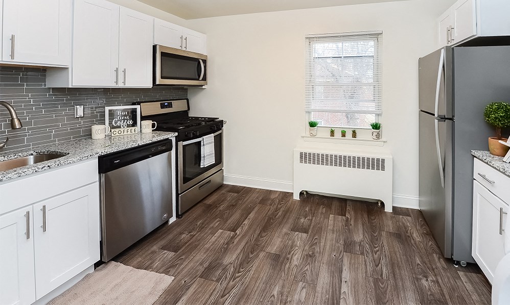 a renovated kitchen with stainless steel appliances and white cabinets