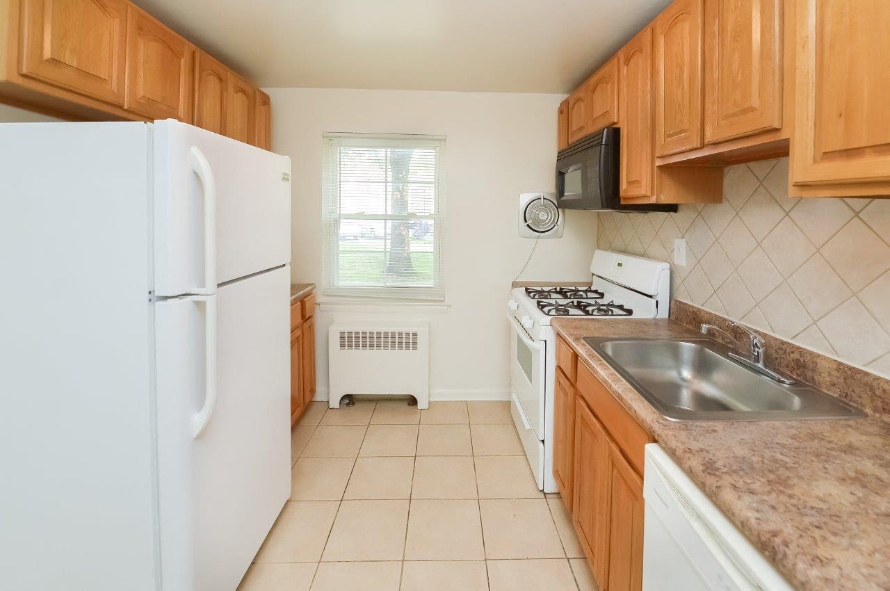 a kitchen with white appliances and wooden cabinets