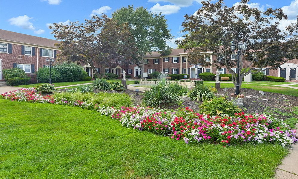 a flower garden in front of a brick building