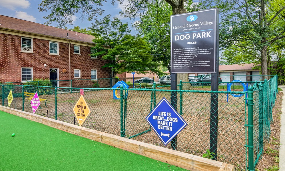 a dog park with a sign in front of a brick building