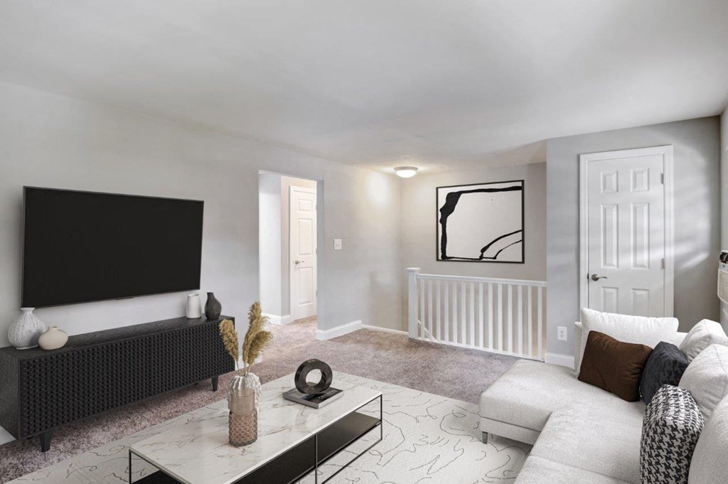 a living room with a white couch and a television