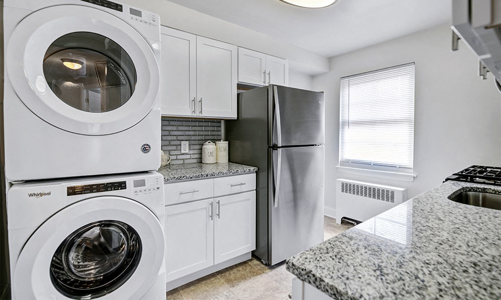 a white kitchen with a washing machine and a refrigerator