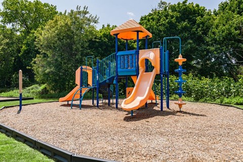 a playground with a blue and orange swing set