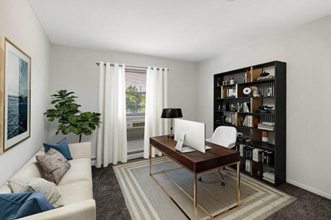 a living room with a desk and a couch