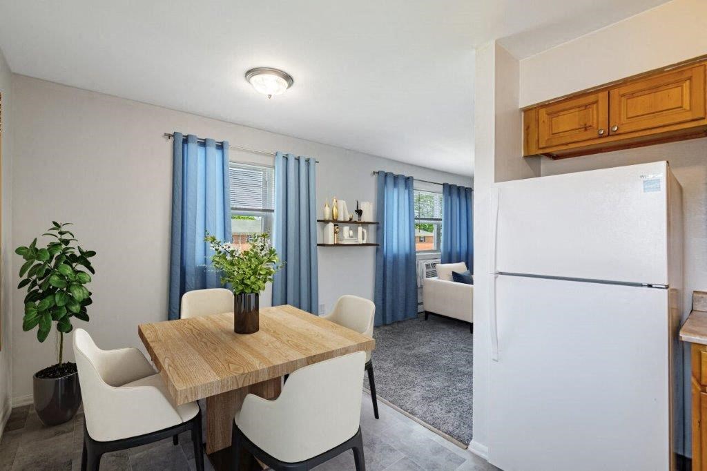 a kitchen with a table and chairs and a refrigerator