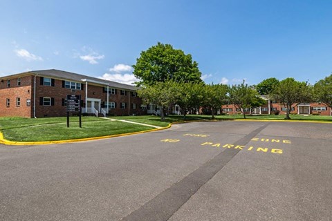 an empty parking lot in front of an apartment building