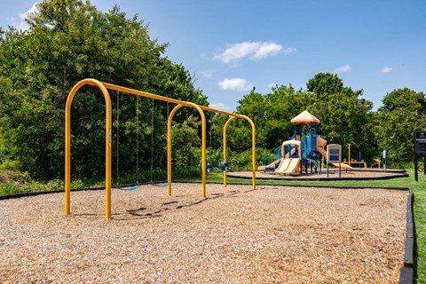 a playground with a swing set in a park