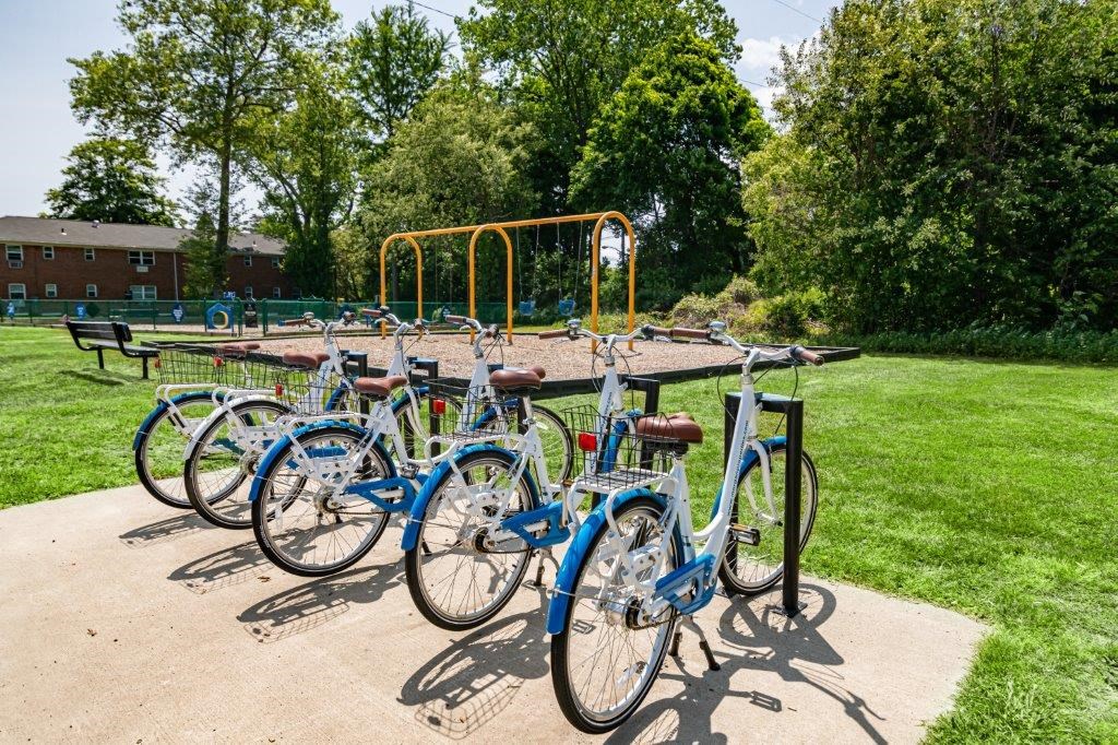 a row of bikes parked in front of a playground