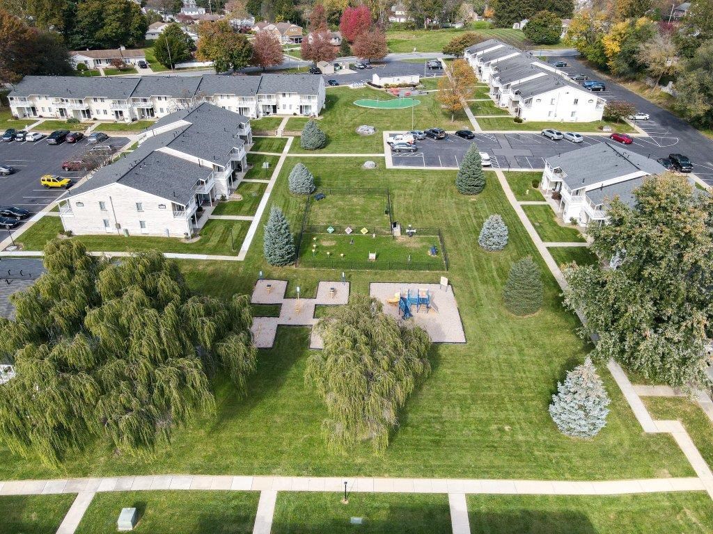 an aerial view of a neighborhood with houses and lawns and trees