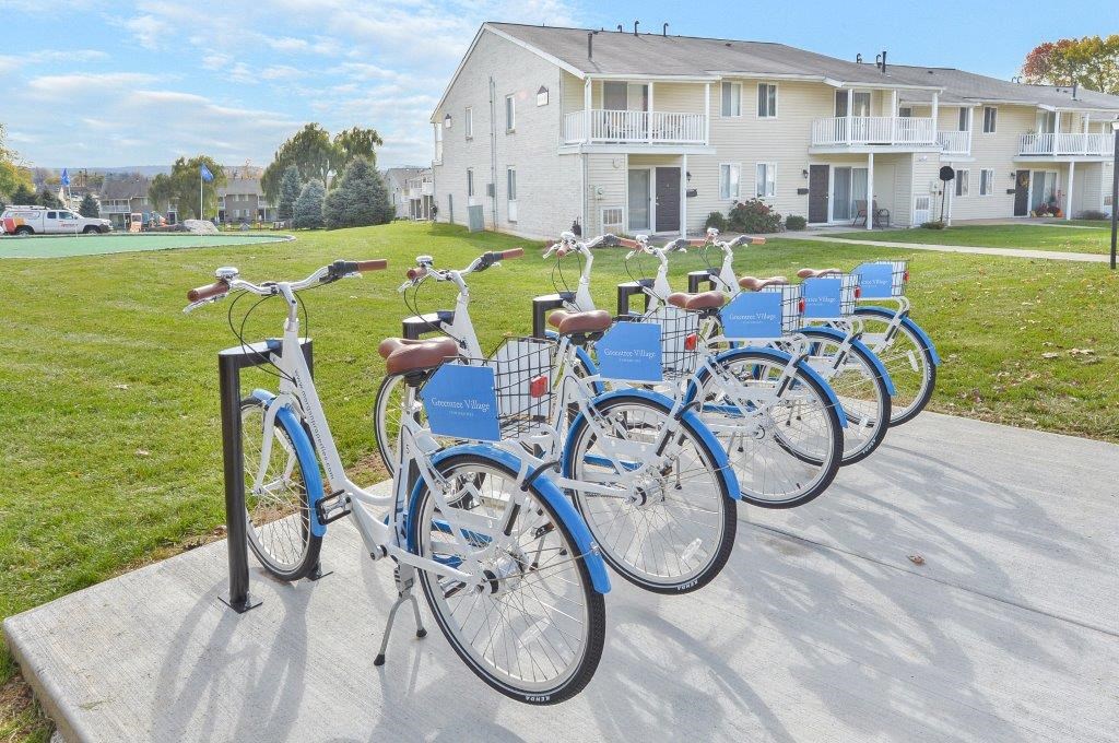 a row of blue bikes parked in front of a house