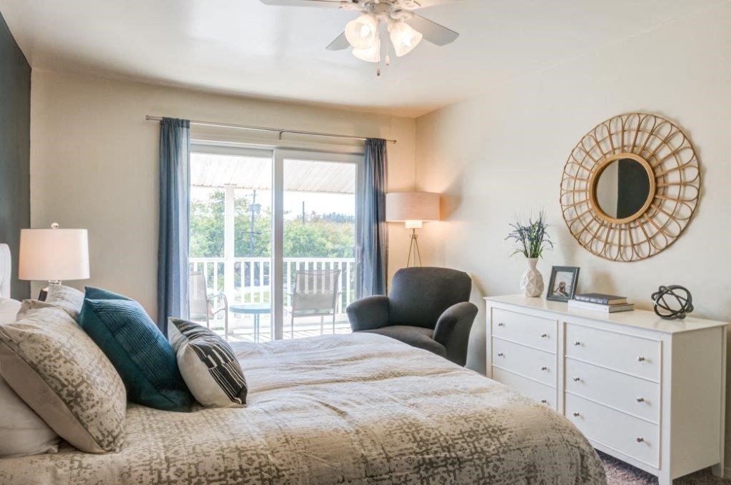 a bedroom with a bed and a sliding glass door to a balcony
