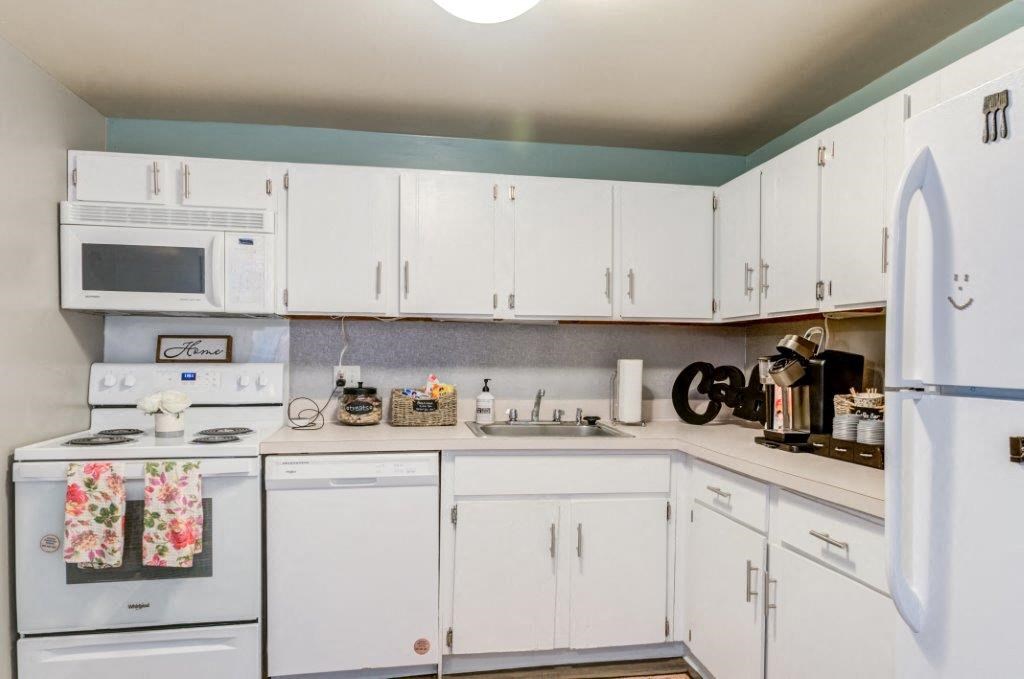 a white kitchen with white appliances and white cabinets
