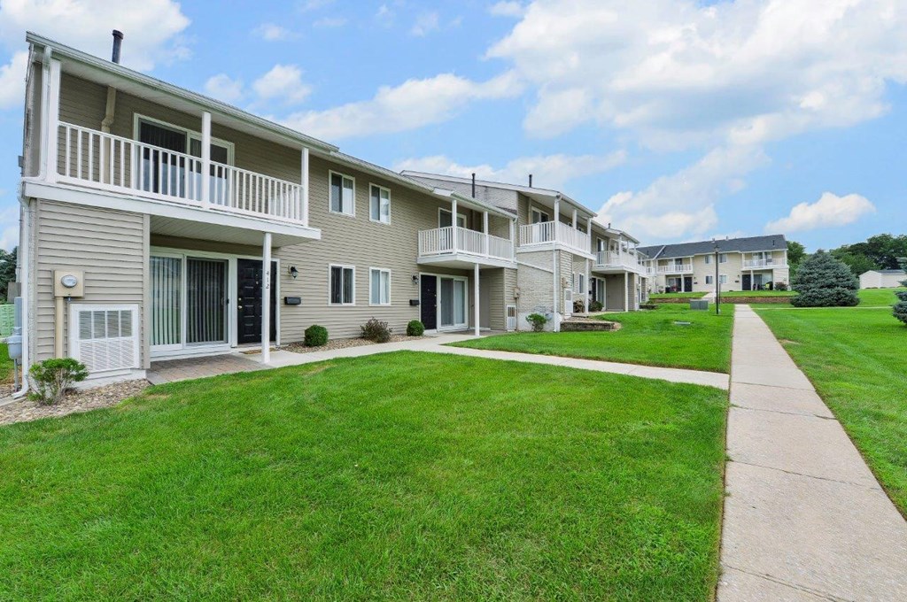 a row of condominiums with a sidewalk in front of them