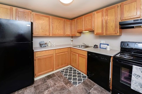a kitchen with black appliances and wooden cabinets