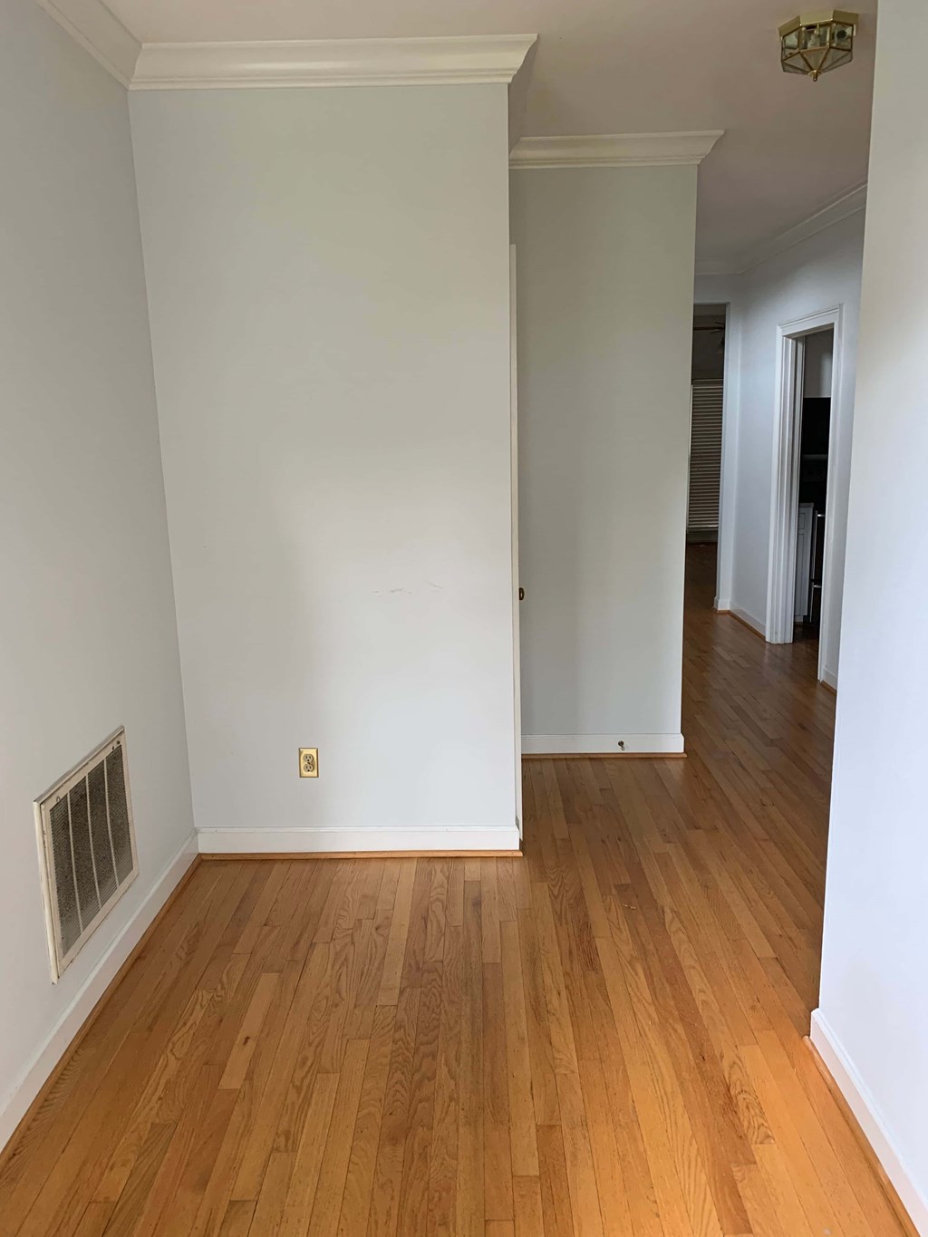 a renovated living room with white walls and wooden floors
