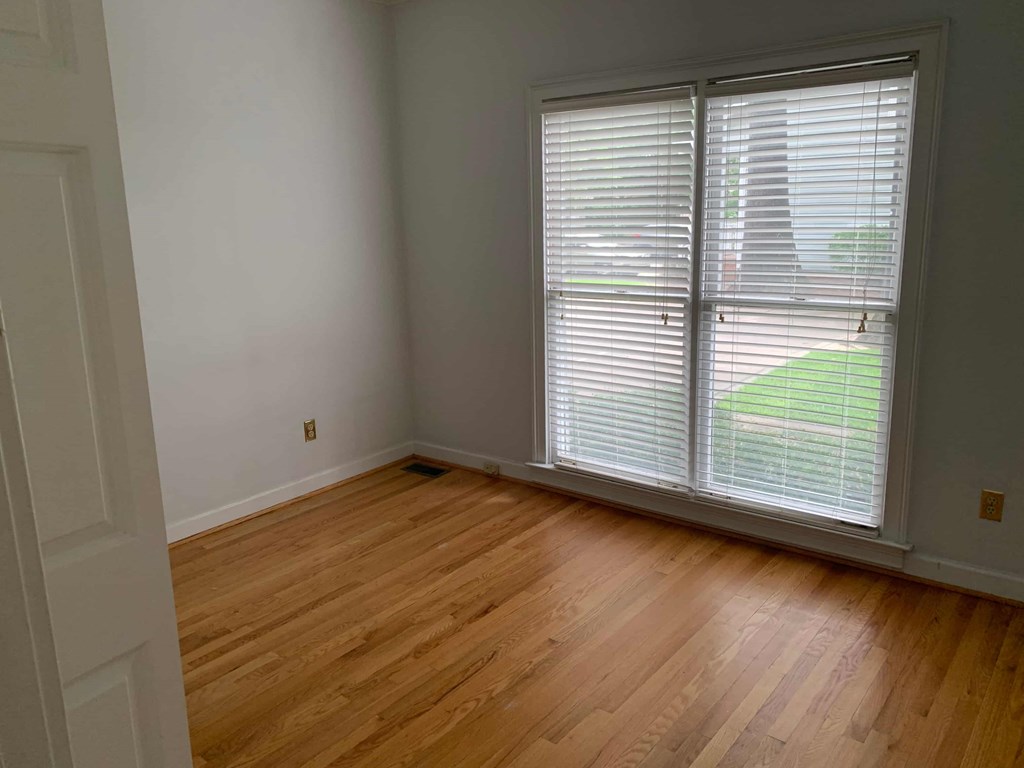 a living room with a large window and wooden floors