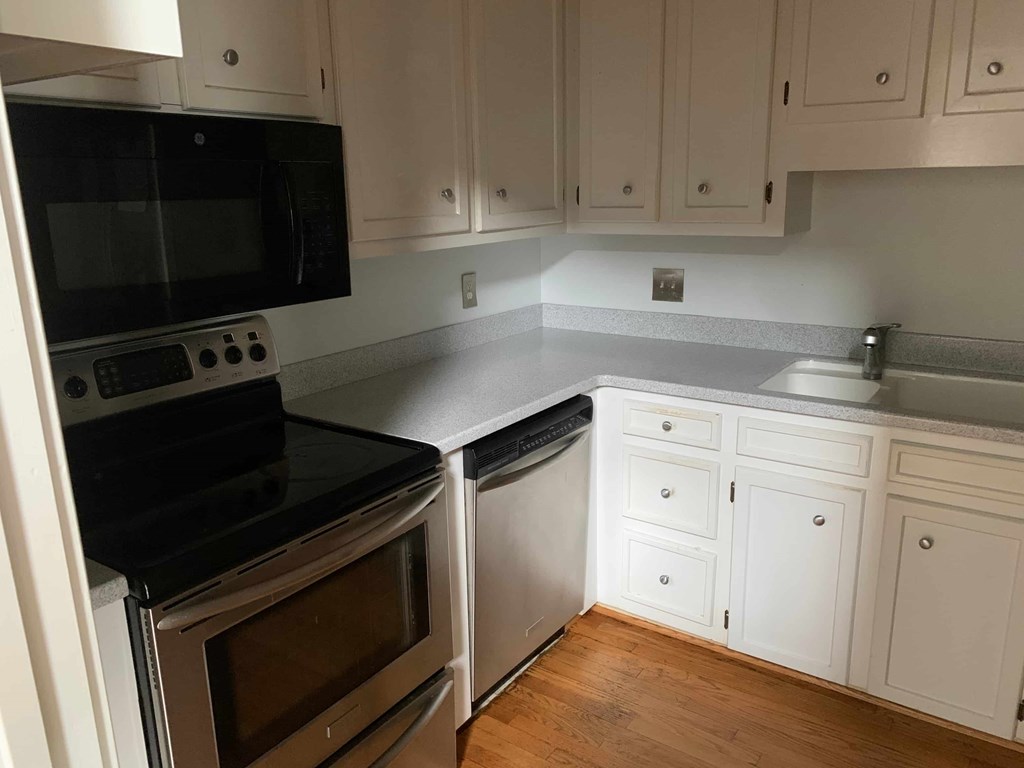 a kitchen with white cabinets and stainless steel appliances