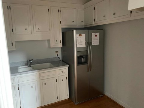 a kitchen with a stainless steel refrigerator and white cabinets
