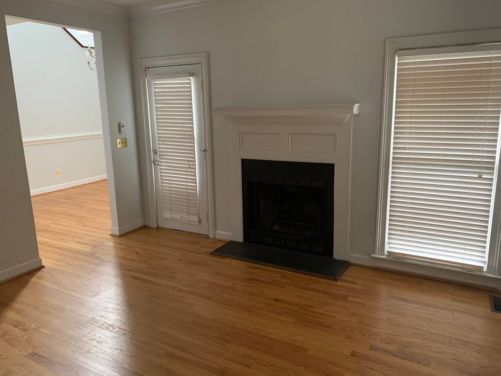 a living room with a fireplace and wooden floors