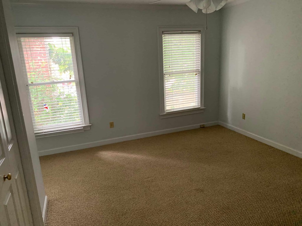 a room with two windows and a carpeted floor