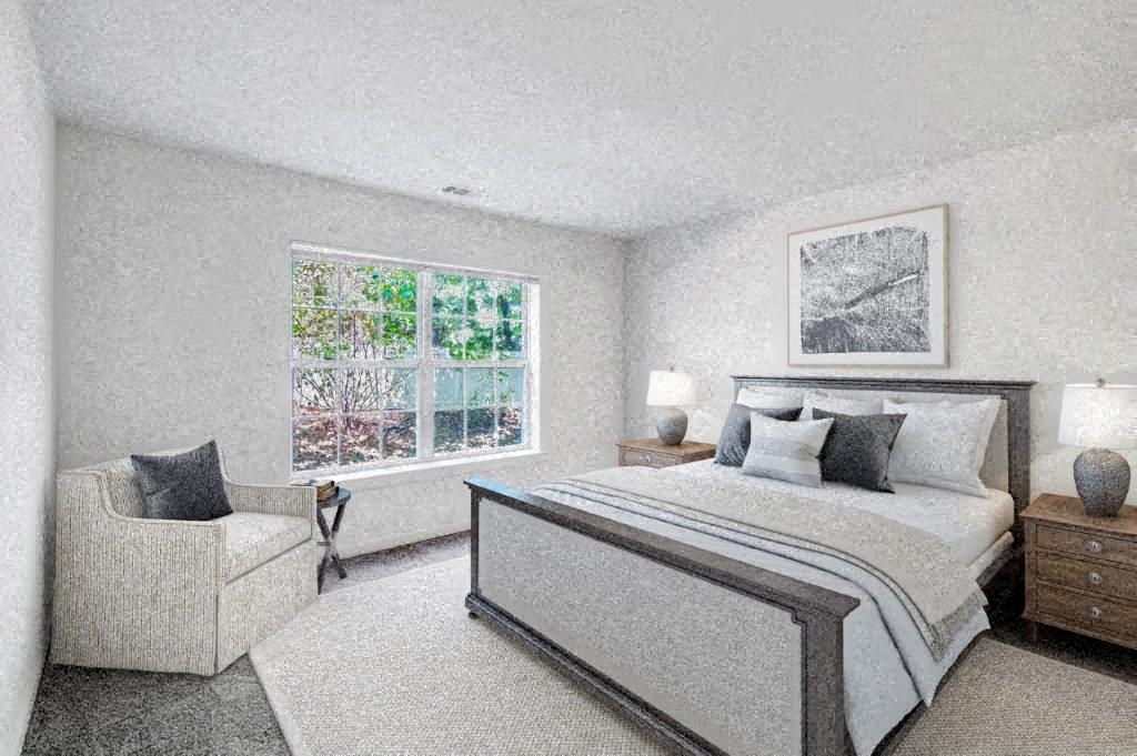 a bedroom with a bed and a chair and a window