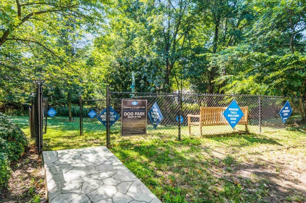 a park with a bench and a fence and a sign