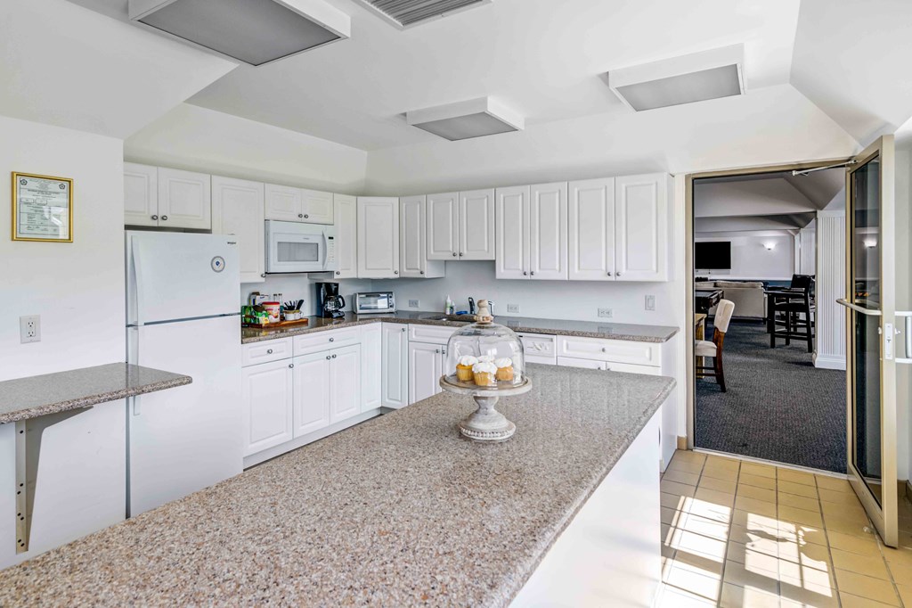 a view of a kitchen with white cabinets and counter tops