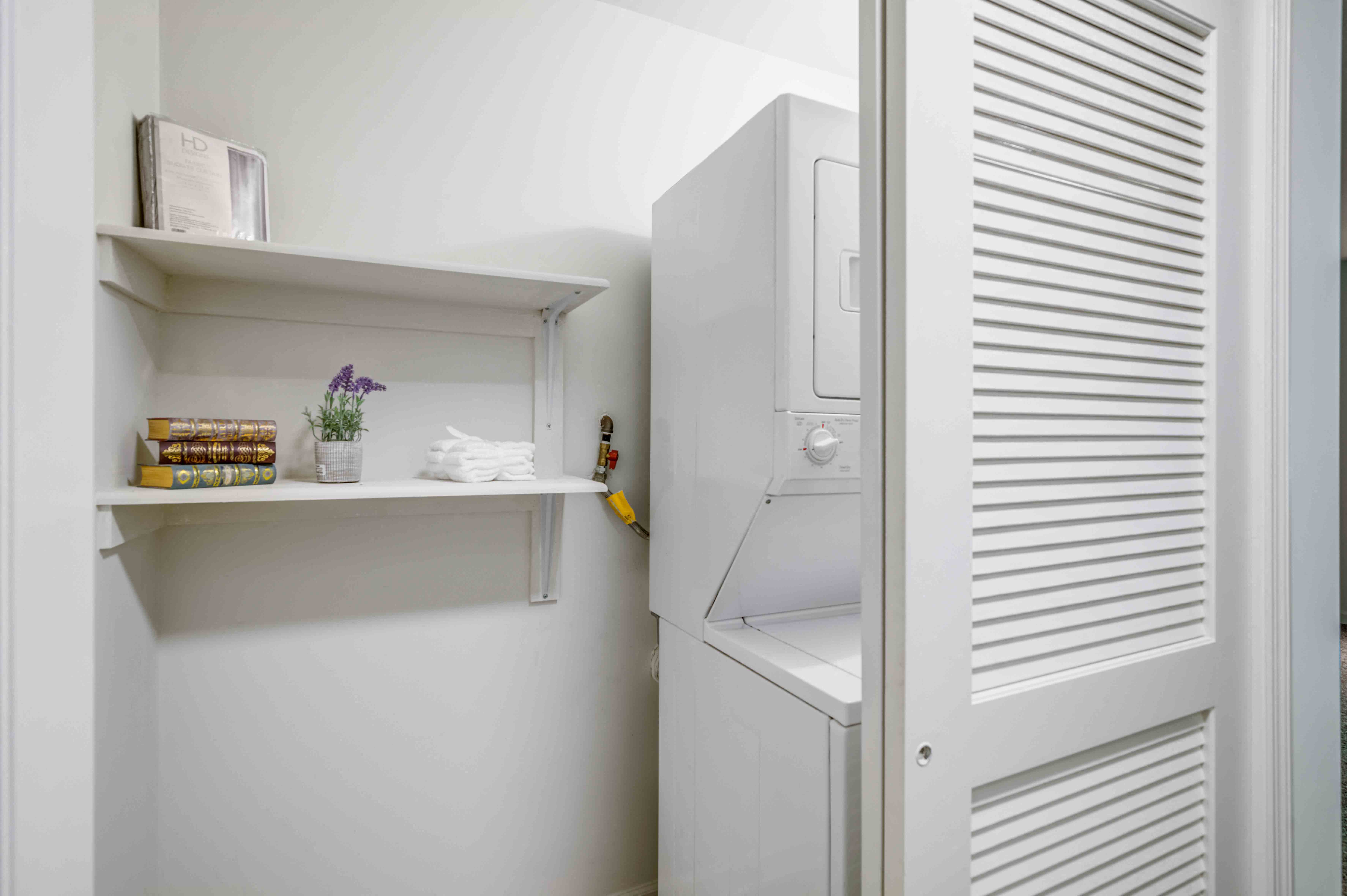a small bathroom with a refrigerator and shelves