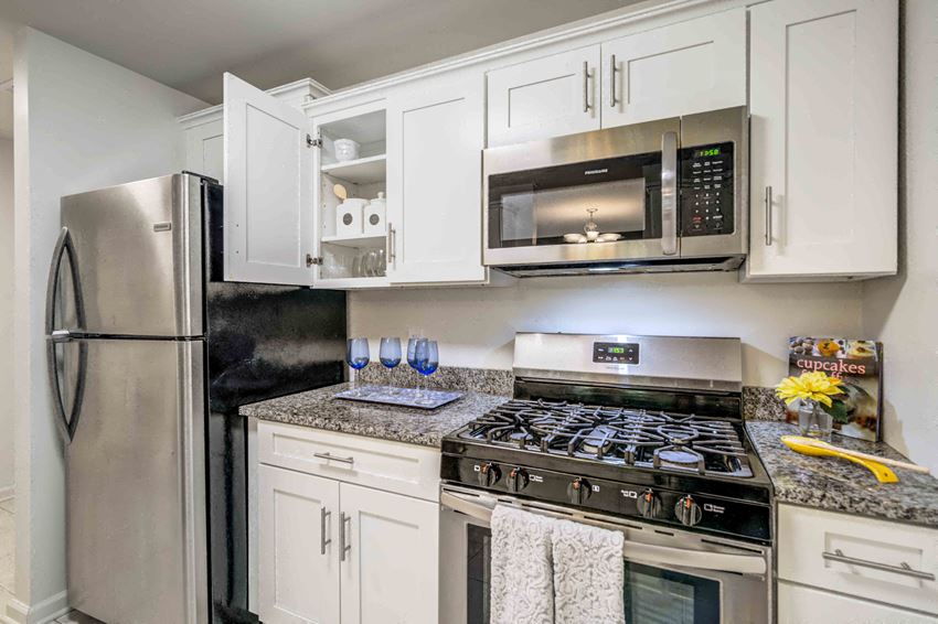 a modern kitchen with stainless steel appliances and white cabinets