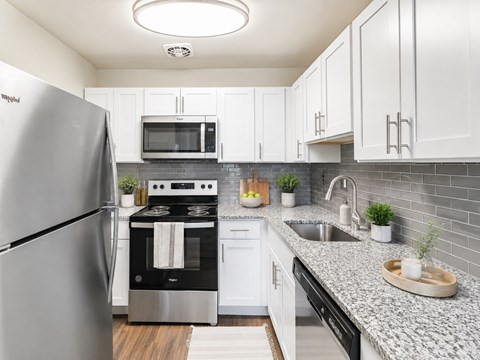 A modern kitchen with a stainless steel refrigerator and black oven.