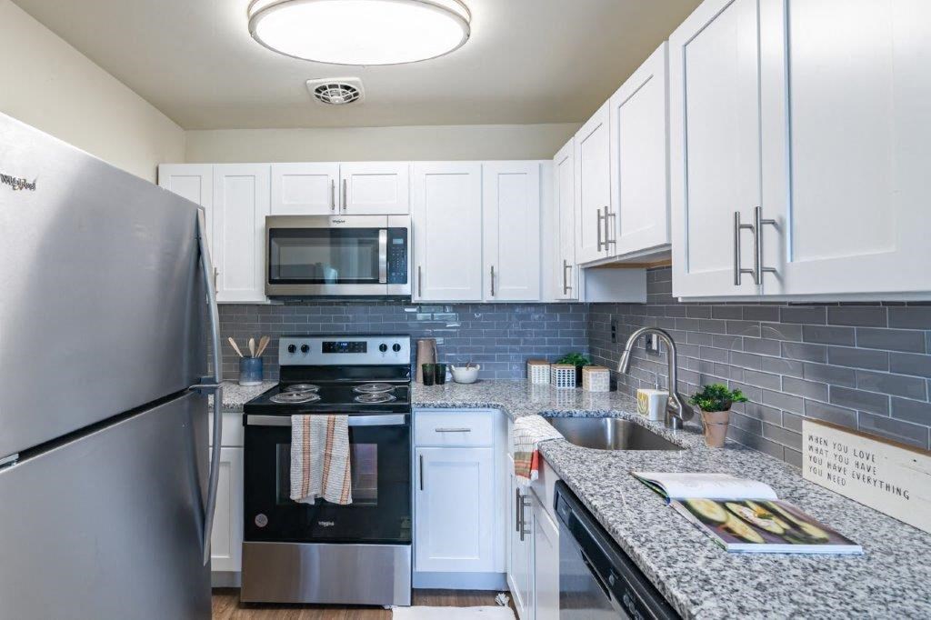 a kitchen with stainless steel appliances and white cabinets