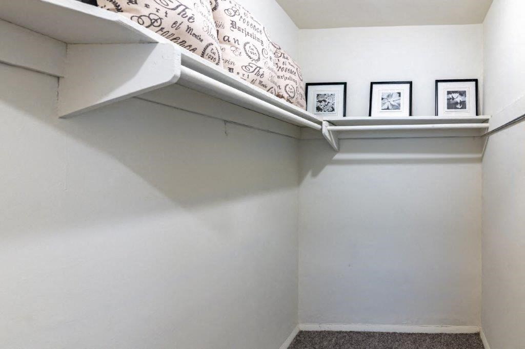 a white room with a shelf and pictures on the wall