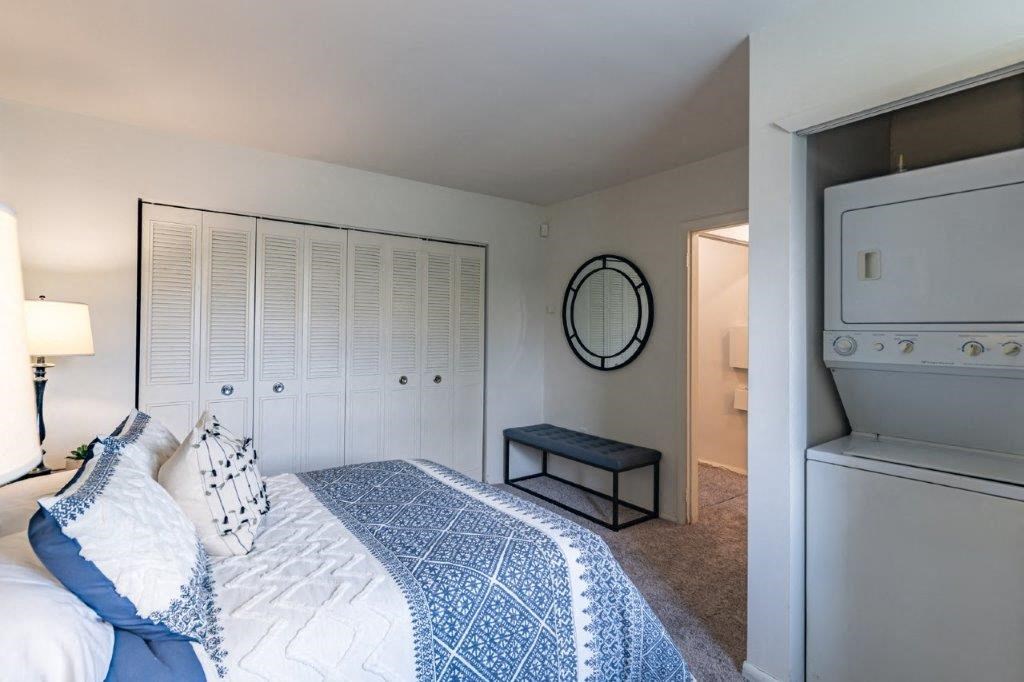 a bedroom with a bed and a washer and dryer