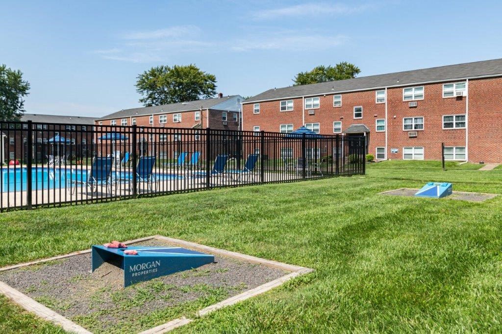 a pool in the grass in front of a building