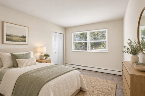 A bedroom with a large bed and a window overlooking a tree-filled landscape.
