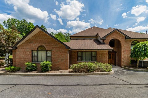 the front of a brick house with a driveway