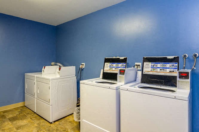 a room with two washing machines and two microwaves